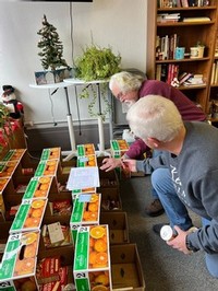 Bill Laffin and Steve Matteson of Keuka Spring Vineyards pack food distribution boxes at the Living Well Mission
